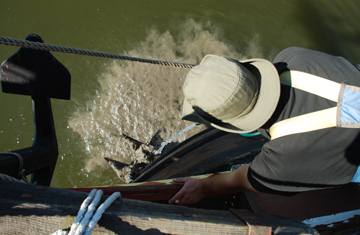 Mr. Schuijer hoses clumps of silt off the anchor.