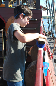 Bennet scrubs the starboard rail.